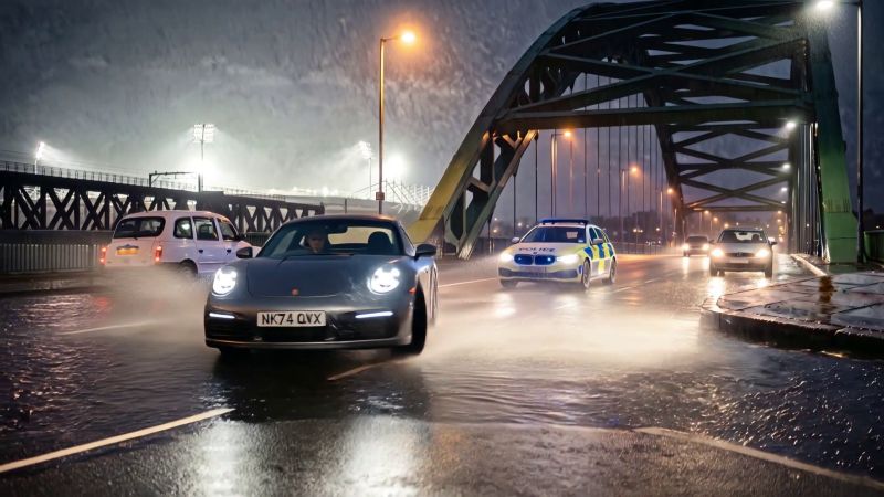 Police cars chase the grey Porsche over the Wearmouth Bridge in the rain